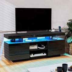 an entertainment center with blue lights and a flat screen tv mounted on it's side