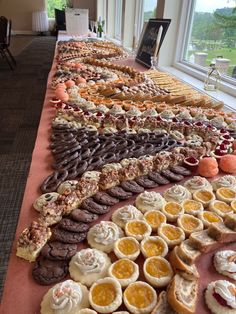 a long table filled with lots of different kinds of pastries