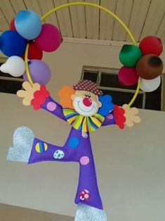 a colorful clown is holding balloons in the shape of a hoop and standing on one leg