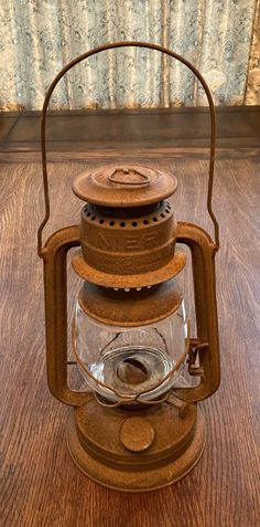 an old fashioned lantern sitting on top of a wooden table