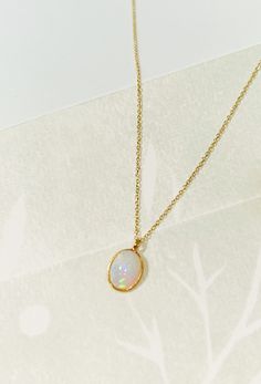 "Oval Opal necklace Oval Opal bezel set pendant on a double rope dainty chain. Charm pendant is made in 18k gold set on a dainty 14k Yellow Gold double rope chain. Necklace length is 16\" and sits under your clavicle. A perfect necklace that is beautiful all year round. + Ethiopian Opal Charm * 9x11mm  + 18k Gold bezel finish + 14k Yellow Gold Double Rope chain. + Approx. 16\" chain + Comes packaged in our signature box + Please note all Mantle 14k gold pieces are made-to-order. In stock items s Opal Necklace Simple, Gold Opal Necklace, Dainty Opal Necklace, خواتم خطوبة, Opal Necklace Gold, October Birthstone Necklace, Beautiful Gold Necklaces, Necklace Opal, Bezel Necklace