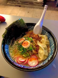 a bowl filled with noodles and vegetables on top of a table