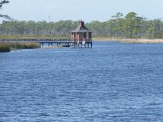 a small house sitting on top of a lake next to a pier