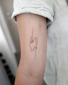 a woman with a tattoo on her arm holding onto a string that is in the shape of a hand