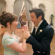 a man and woman in formal wear dancing together