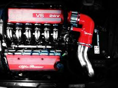 the engine compartment of a car is shown with red hoses attached to it's pipes