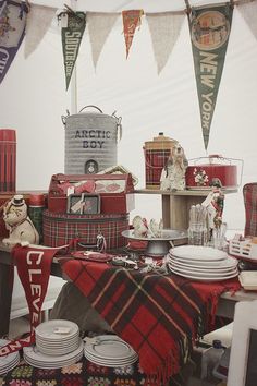 a table covered in plaid cloths and other items for sale at a flea market