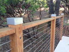 a wooden and metal fence in the woods