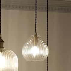 two glass pendant lights hanging from a ceiling