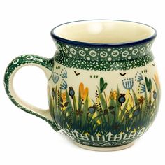 a green and white mug with flowers on it