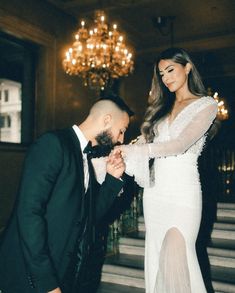 a woman in a white dress standing next to a man