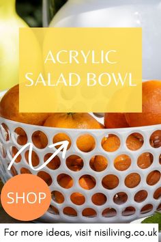 a white bowl filled with oranges on top of a table