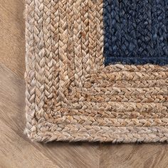 an area rug with different colors and patterns on top of wood flooring that looks like woven fabric