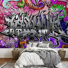 a bed sitting in front of a graffiti covered wall