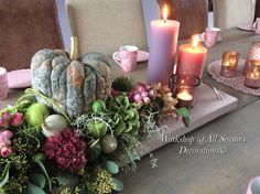 the table is set with candles, flowers and succulents