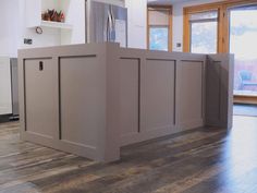 an empty kitchen with wooden floors and cabinets