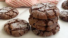 chocolate cookies are stacked on top of each other in front of a red and white towel