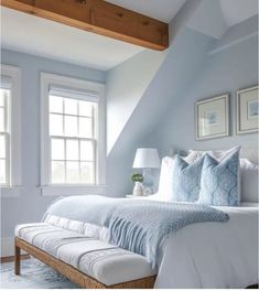 a bedroom with blue walls and white bedding