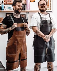 two tattooed men standing next to each other