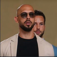 two men wearing sunglasses and one is looking off to the side with his head tilted