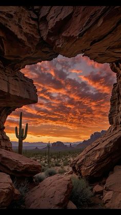 the sun is setting in the desert with rocks and cacti on it's sides