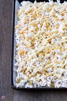 a tray filled with popcorn on top of a wooden table