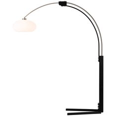 a lamp that is on top of a white wall and has a black pole with a light