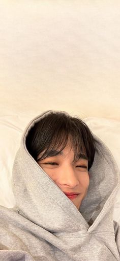 a young boy laying in bed with his head tucked under the covers and covering him