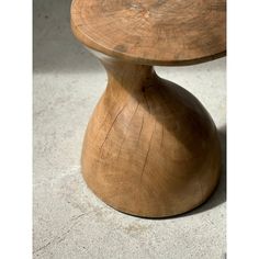 a wooden stool sitting on top of a cement floor