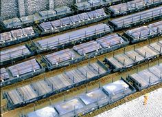 an aerial view of several train cars parked on the tracks and one man standing in front of them