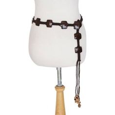 a white mannequin with wooden beads and chains on it's torso,