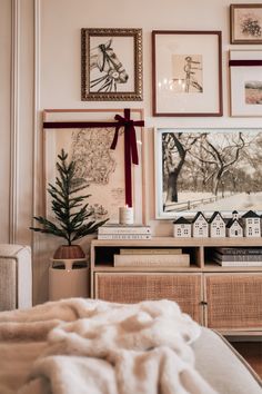 a bedroom with pictures on the wall and a christmas tree