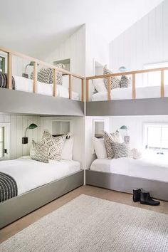 two beds in a room with bunk beds on each side and stairs to the second floor