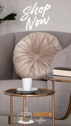 a coffee table with a cup on it next to a couch and pillow that says shop now