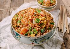 two bowls filled with rice and shrimp on top of a table