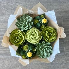 a bouquet of succulents in a paper wrapper