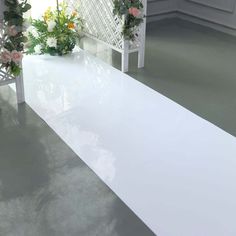 a white bench with flowers on it in a room