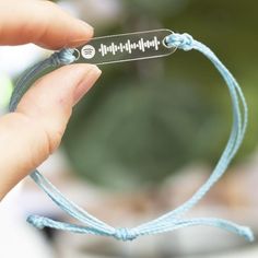 a person holding a blue string with a sound wave on it