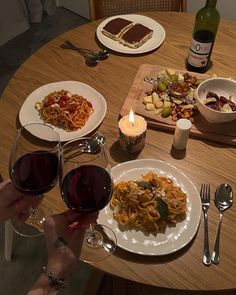 a table topped with plates of food and glasses of wine