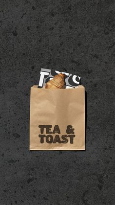 a brown paper bag with tea and toast on it