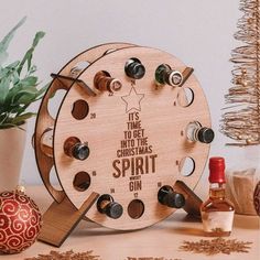 a wooden clock sitting on top of a table next to a potted plant and bottle