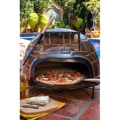 a pizza sitting on top of an outdoor oven