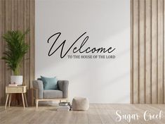 a living room with a wall decal that says welcome to the house of the lord