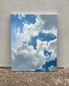 an image of some clouds in the sky on a white wall with gravel and rocks