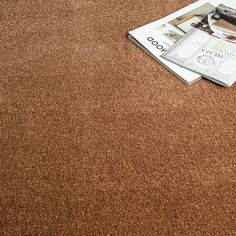 a magazine laying on top of a brown carpet