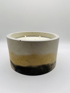 a black and white candle holder with two candles in it's center, on a white background