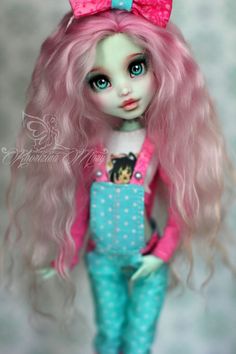 a doll with pink hair and blue pants is wearing a pink bow tie, polka dot top