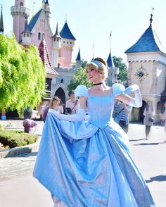 a woman in a blue dress is walking down the street