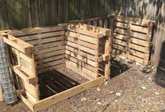 two wooden crates sitting next to each other on the ground in front of a fence