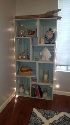 a book shelf filled with books on top of a hard wood floor next to a window